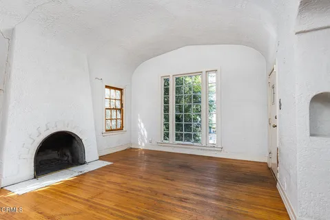 a view of empty room with windows and wooden floor
