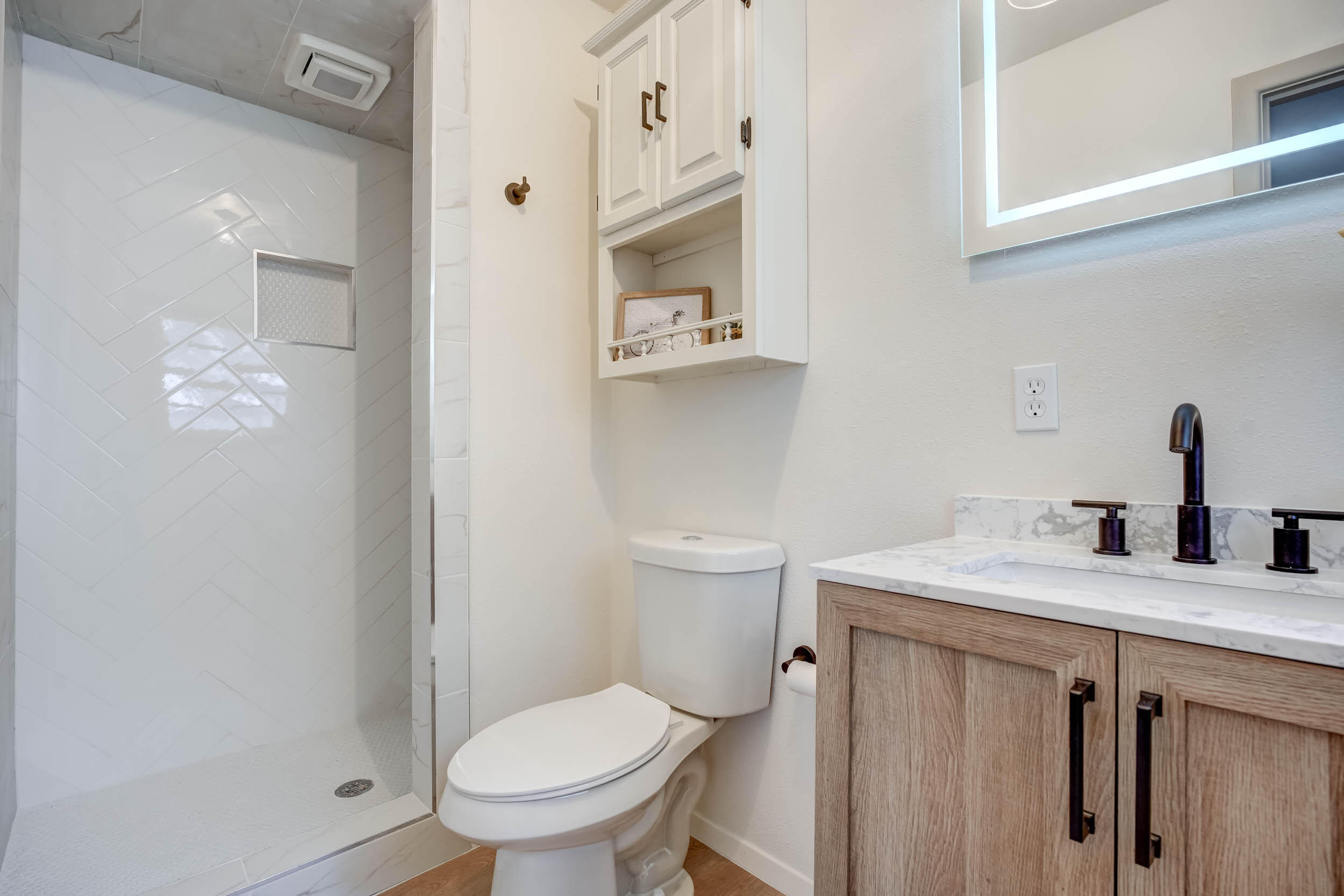 2101 64th Street Lubbock, TX 79412 - Photo 21 of 30 a bathroom with a granite countertop toilet sink and a mirror