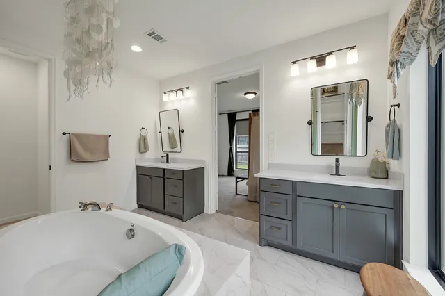 a bathroom with a tub sink and mirror