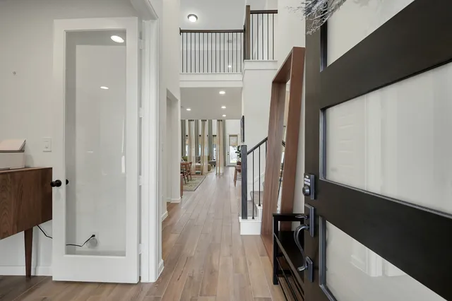 a view of a hallway with wooden floor and staircase