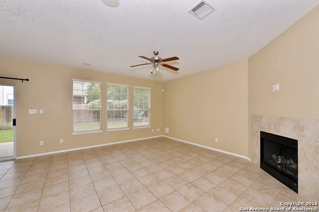 a view of an empty room with a fireplace and a window