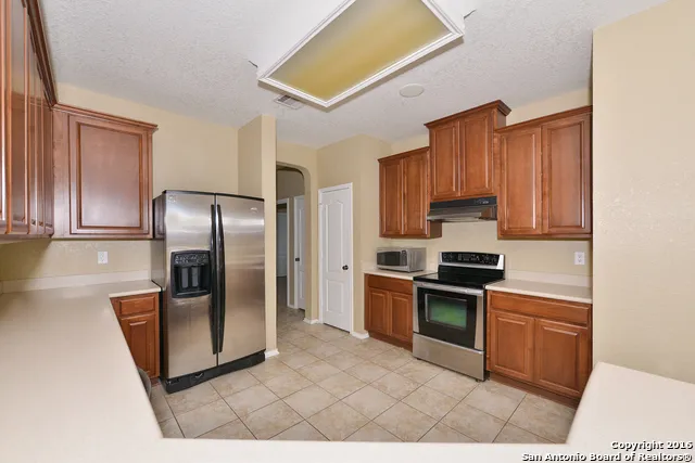 a kitchen with stainless steel appliances granite countertop a stove a refrigerator and a sink