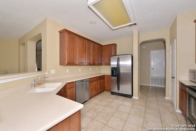 a large kitchen with granite countertop a sink and cabinets