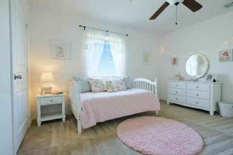 a spacious bedroom with a bed a window and dresser