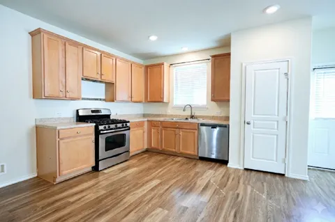 a kitchen with a stove a sink and a window