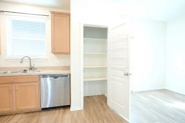 a kitchen with a sink cabinets and a window