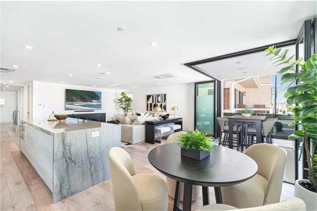 a living room with furniture and a dining table with potted plants