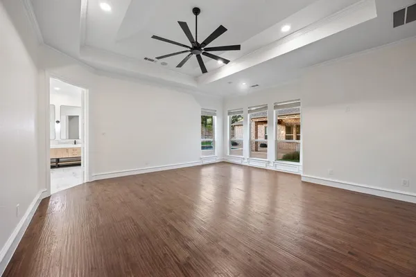 a view of an empty room with window and wooden floor