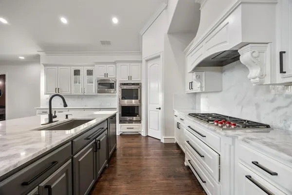a kitchen with stainless steel appliances granite countertop a sink stove and cabinets