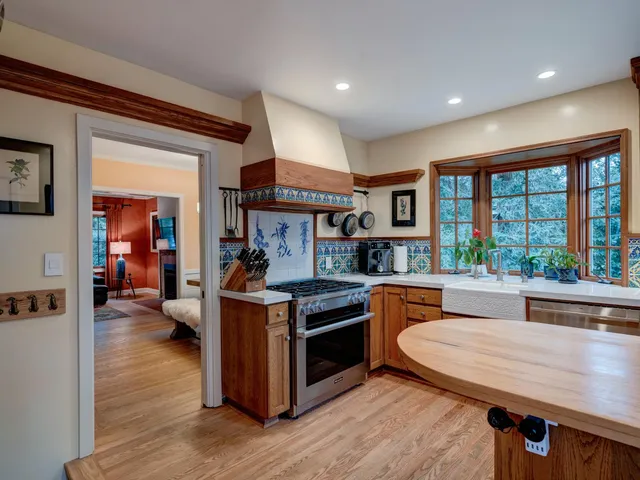 a kitchen with a stove and a wooden floor