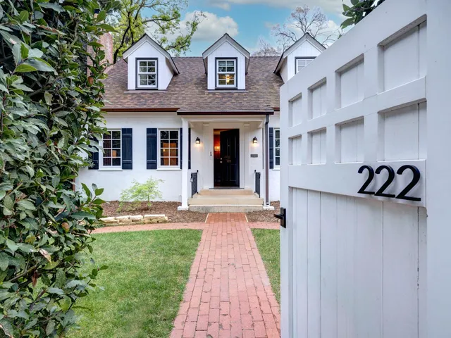 a view of a brick house with many windows and plants