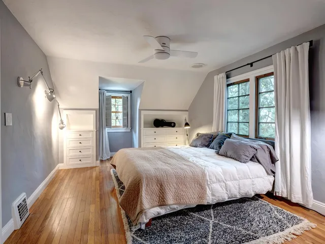 a bedroom with a bed and wooden floor