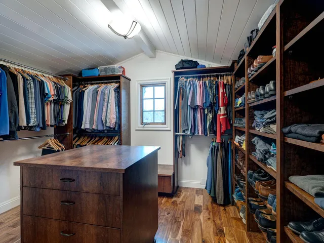 a view of walk in closet with clothes and shoes