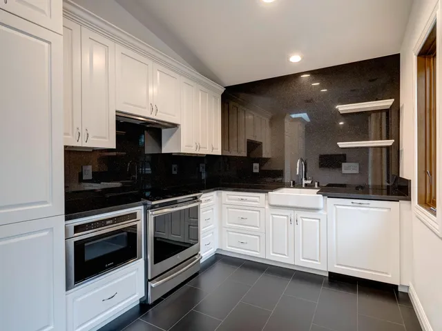 a kitchen with stainless steel appliances white cabinets and sink