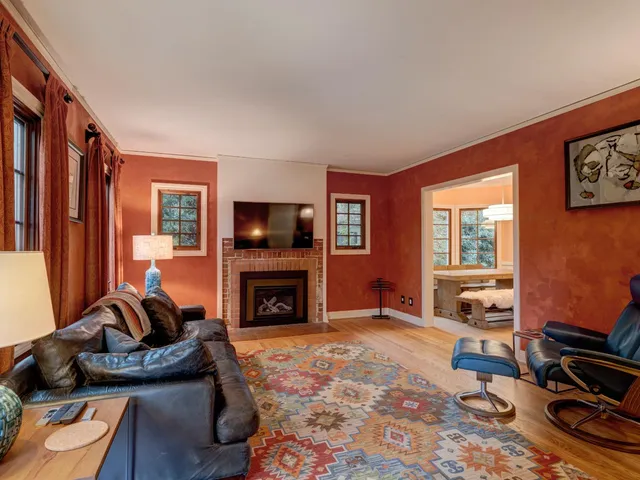 a living room with furniture hard wood floor and a fireplace
