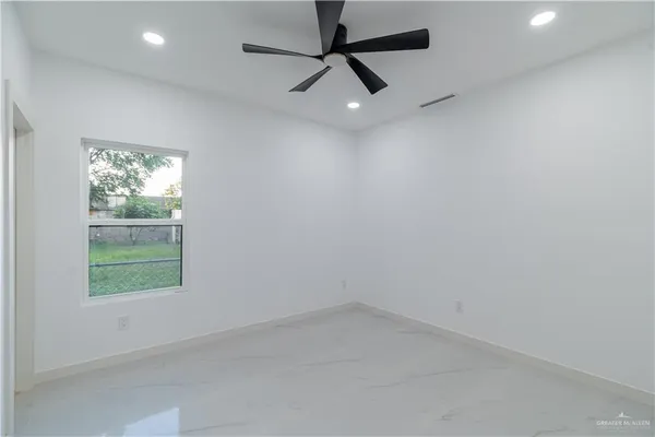 an empty room with a window and a fan