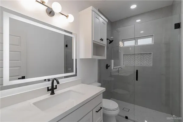 a bathroom with a sink a toilet and shower