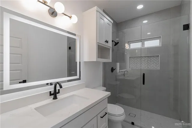 a bathroom with a sink a toilet and shower