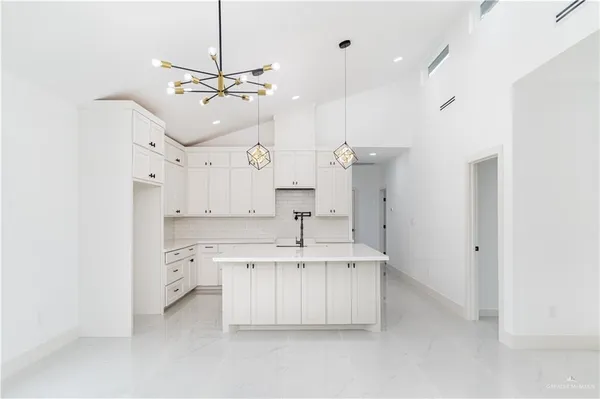 a kitchen with kitchen island a sink stainless steel appliances and cabinets