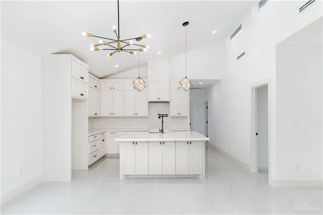 a kitchen with kitchen island a sink stainless steel appliances and cabinets