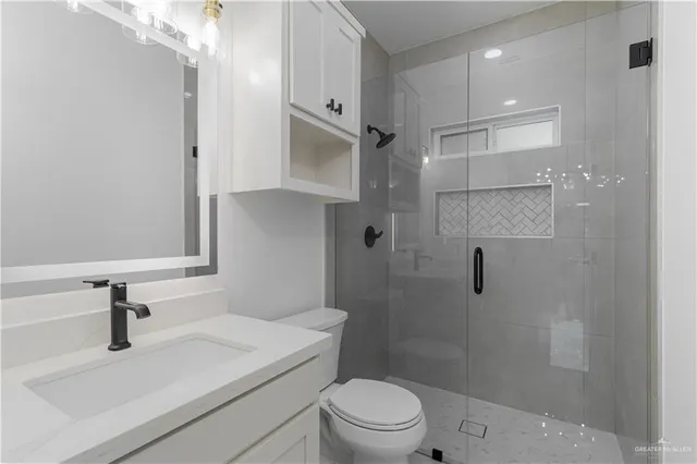 a bathroom with a sink a toilet and shower