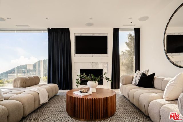 a living room with furniture a fireplace and a flat screen tv