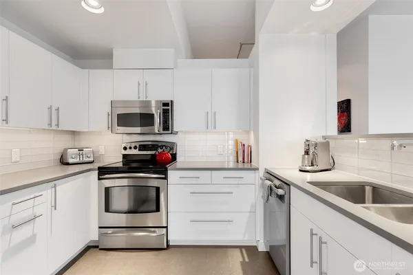 a kitchen with white cabinets stainless steel appliances and sink