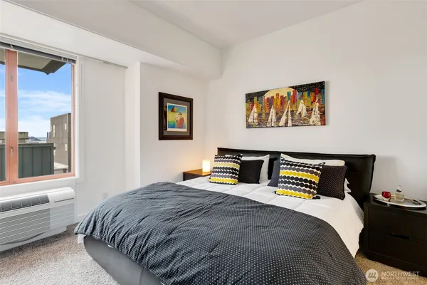 a bedroom with a bed and a painting on the wall