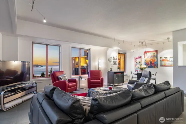 a living room with furniture a rug and wall paintings