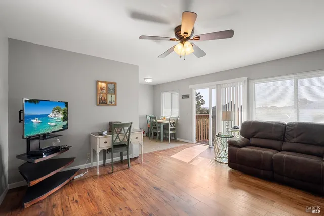 a living room with furniture and a flat screen tv with wooden floor