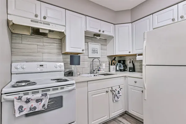 a kitchen with white cabinets and white appliances