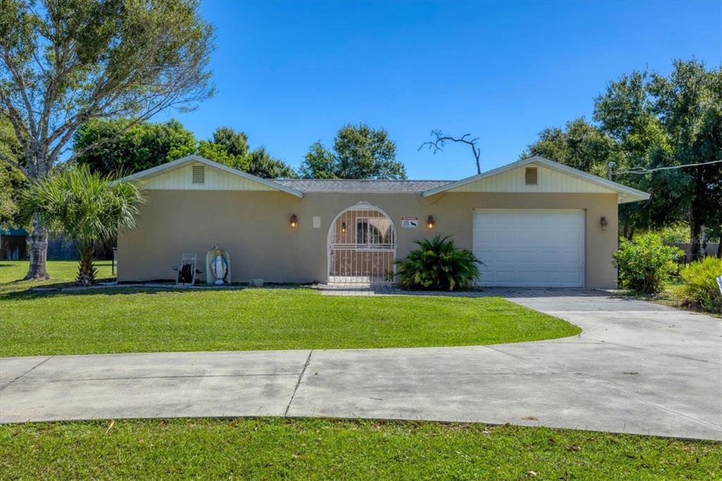 1135 Range Road Englewood, FL 34224 - Photo 11 of 42 a front view of a house with a yard and garage