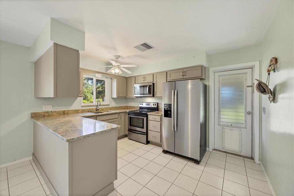 1135 Range Road Englewood, FL 34224 - Photo 18 of 42 a kitchen with a refrigerator sink and cabinets