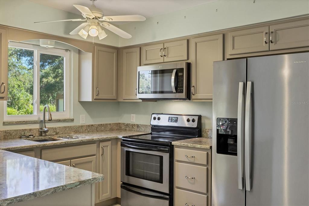1135 Range Road Englewood, FL 34224 - Photo 19 of 42 a kitchen with stainless steel appliances granite countertop a refrigerator a stove a sink and a microwave