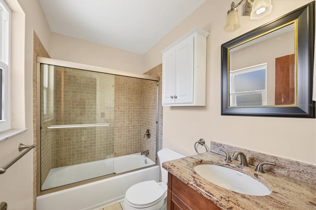 1135 Range Road Englewood, FL 34224 - Photo 27 of 42 a bathroom with a granite countertop sink toilet and shower