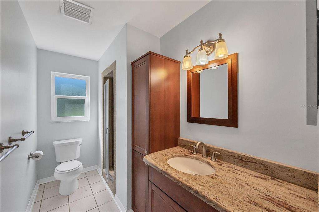 1135 Range Road Englewood, FL 34224 - Photo 30 of 42 a bathroom with a granite countertop sink and a mirror