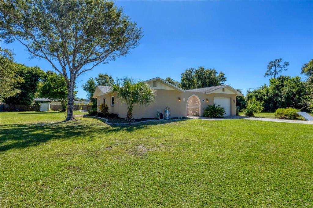 1135 Range Road Englewood, FL 34224 - Photo 10 of 42 a backyard of a house with plants and large tree