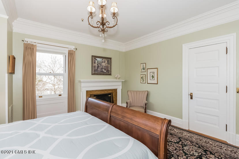 432 Field Point Road Greenwich, CT 06830 - Photo 35 of 56 a bedroom with a bed and a chair with the bookshelf