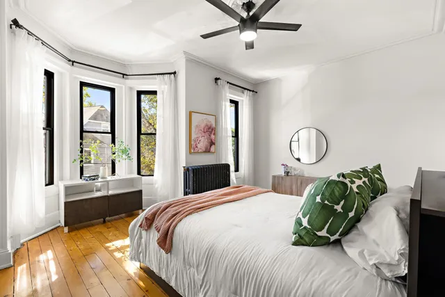 a bedroom with a bed mirror and window