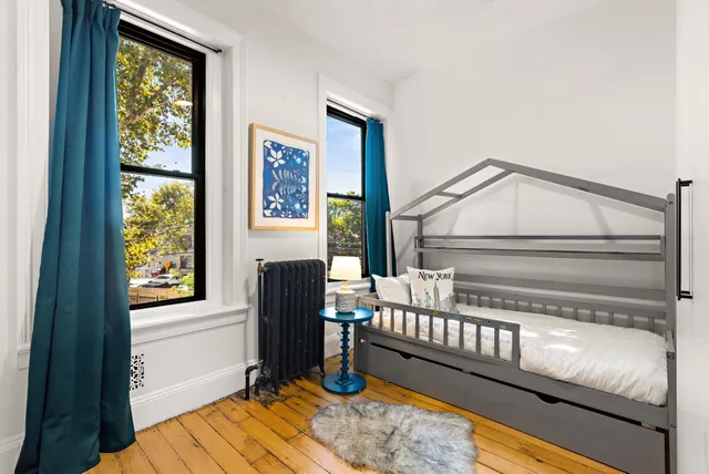 a view of a bedroom with wooden floor and windows