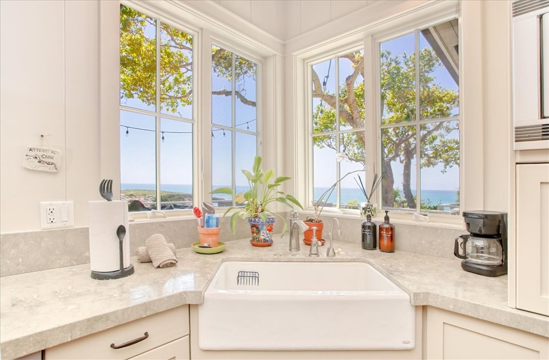 404 Huntington Road Cambria, CA 93428 - Photo 19 of 72 a bathroom with a granite countertop sink and a large window