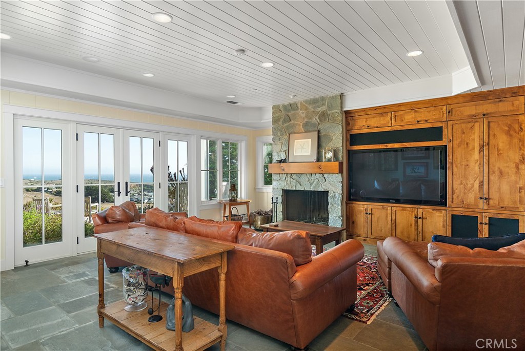 404 Huntington Road Cambria, CA 93428 - Photo 58 of 72 a living room with furniture a fireplace and a floor to ceiling window
