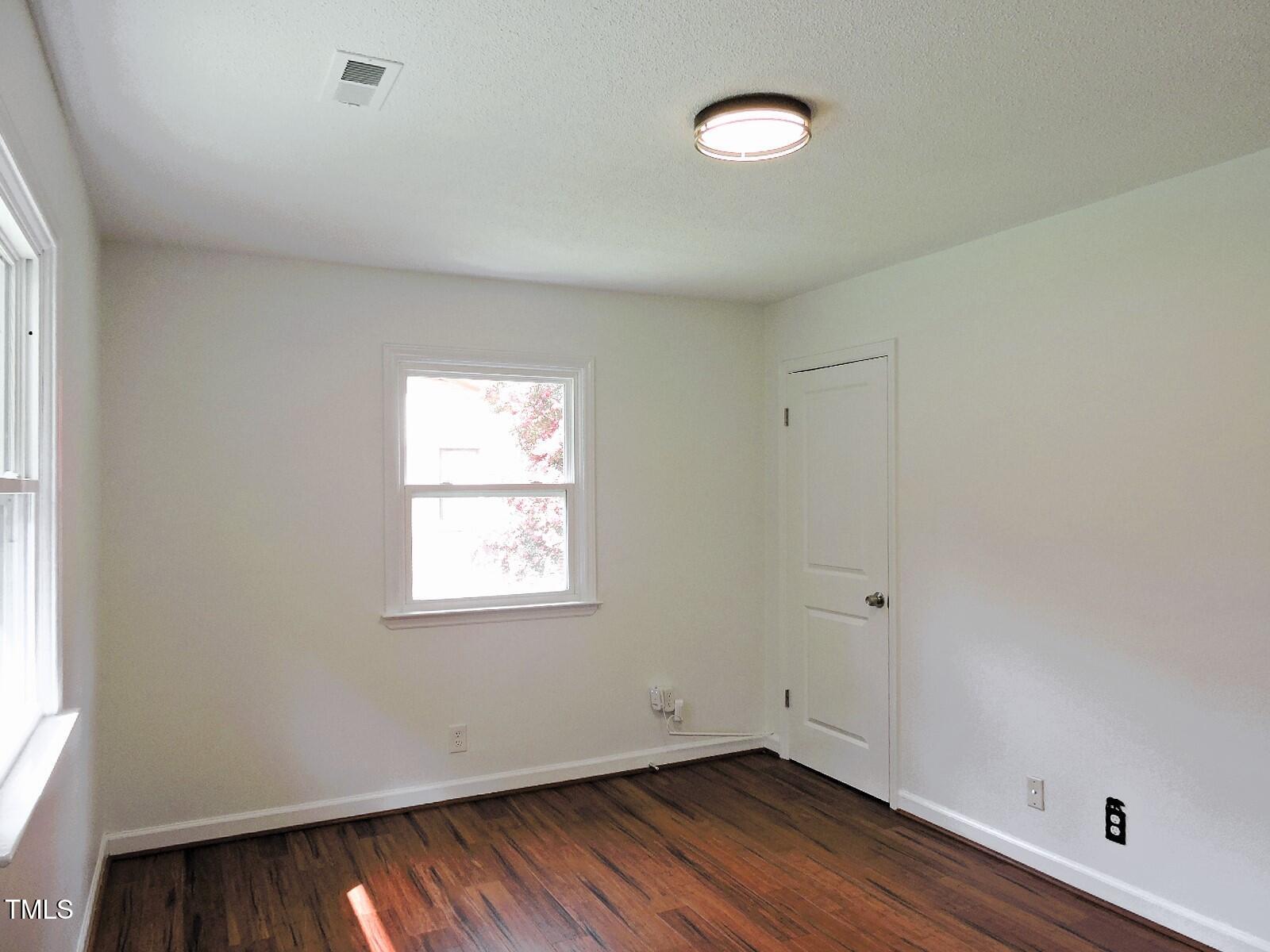 1620 Riddle Road Durham, NC 27713 - Photo 14 of 28 a view of an empty room with wooden floor and a window