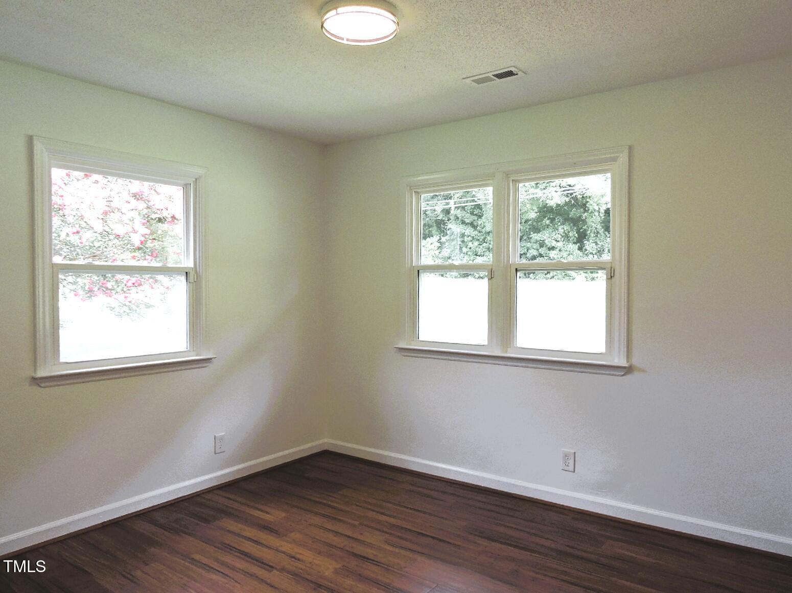 1620 Riddle Road Durham, NC 27713 - Photo 18 of 28 an empty room with wooden floor and windows