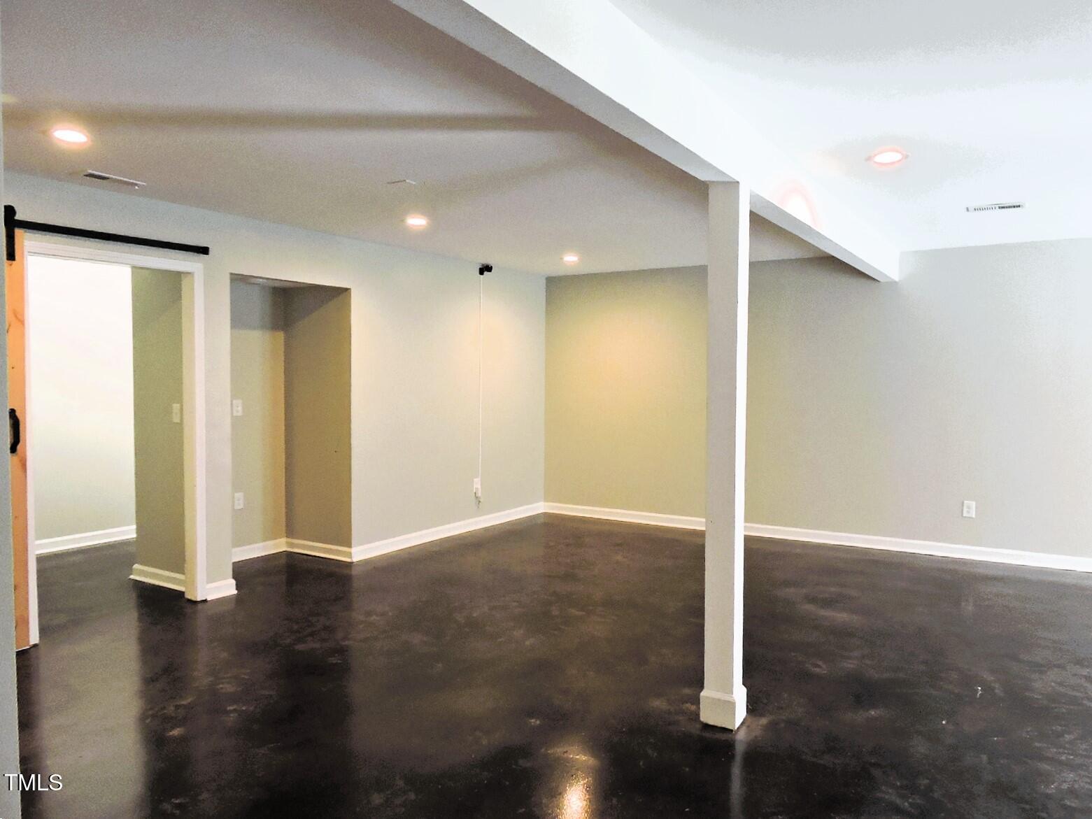 1620 Riddle Road Durham, NC 27713 - Photo 20 of 28 an empty room with wooden floor and entrance to other room