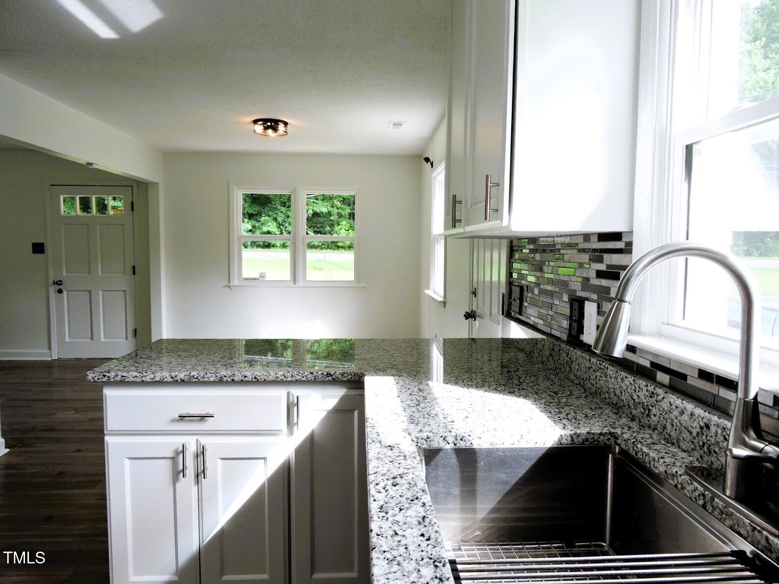1620 Riddle Road Durham, NC 27713 - Photo 5 of 28 a kitchen with granite countertop a sink and a stove top oven