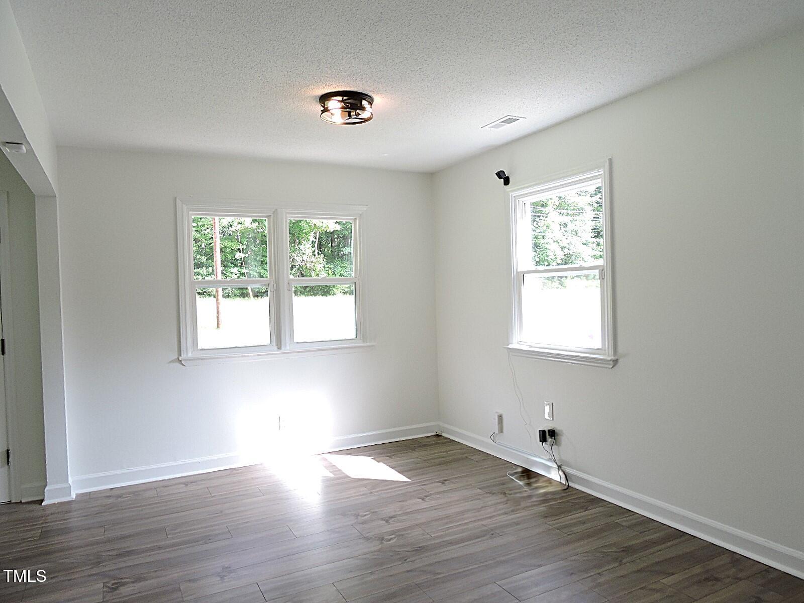 1620 Riddle Road Durham, NC 27713 - Photo 7 of 28 a view of an empty room with wooden floor and a window