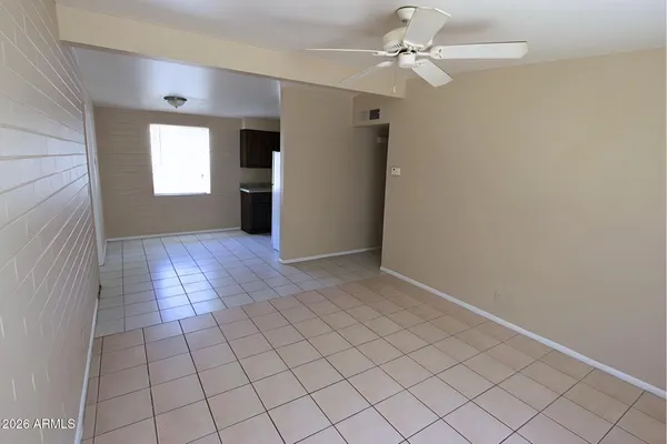 an empty room with windows and fan