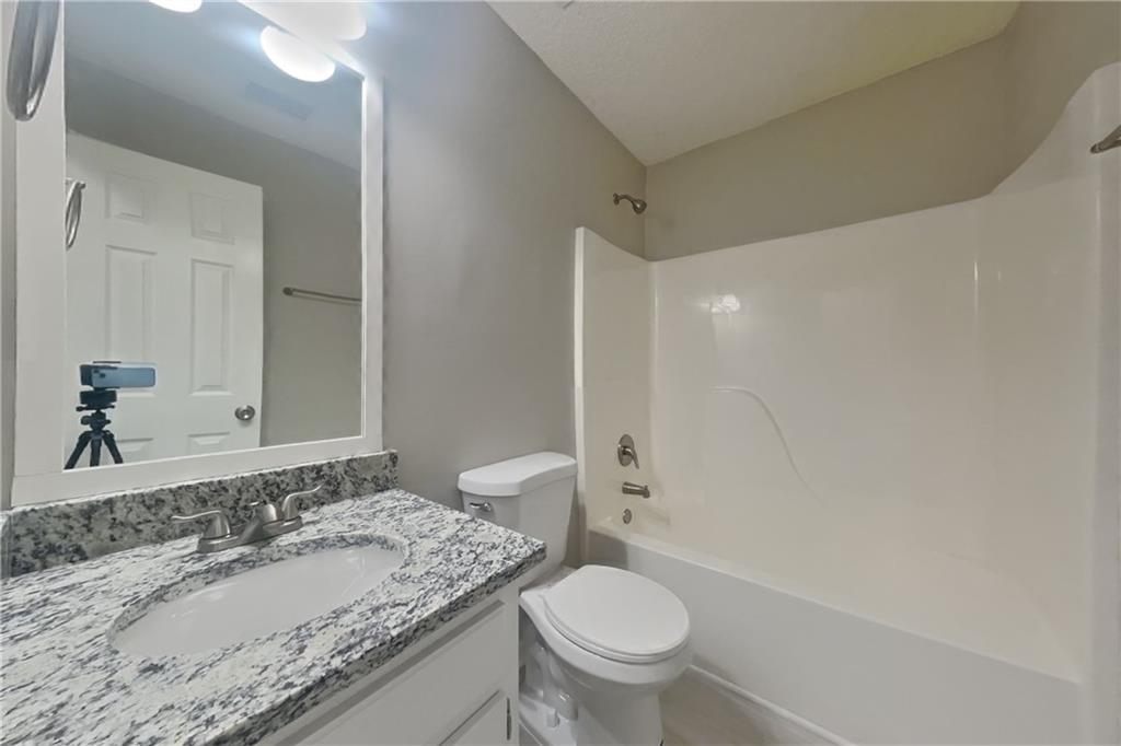 257 Ashland Park Court Southeast Lawrenceville, GA 30045 - Photo 16 of 21 a bathroom with a granite countertop sink toilet and shower