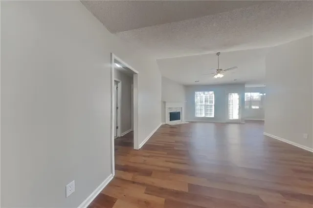 a view of an empty room with window and wooden floor